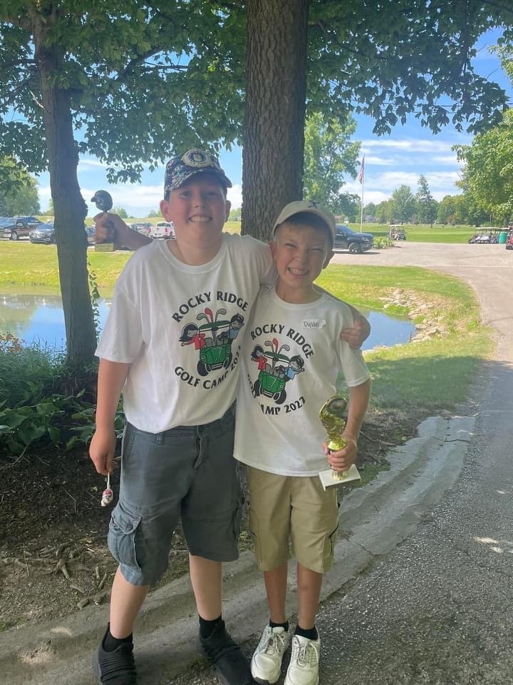 Hunter Zachary and Dylan Priddy show off their camp t-shirts while posing for a photo.